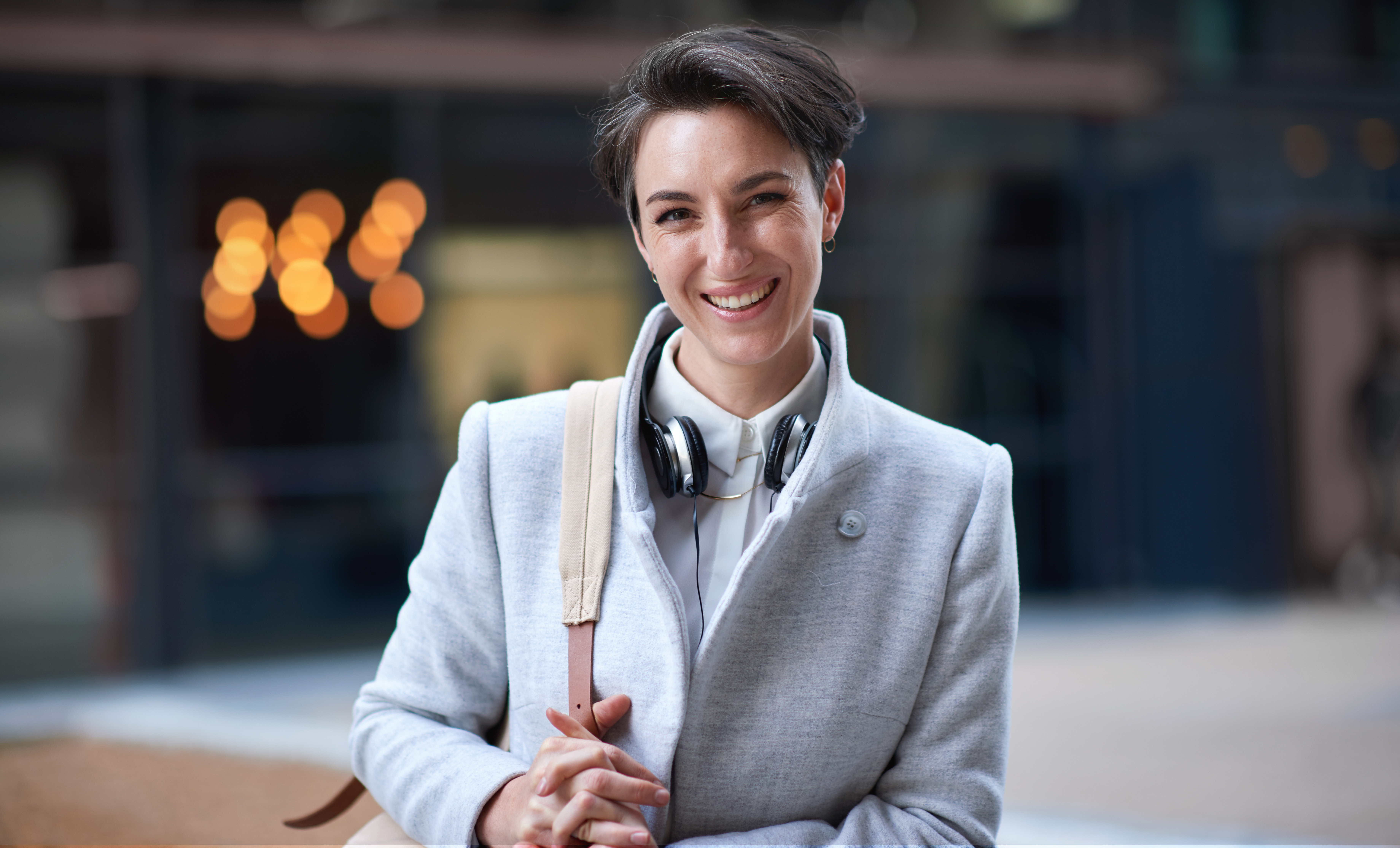 Portrait confident young business woman smiling in city success testimonial