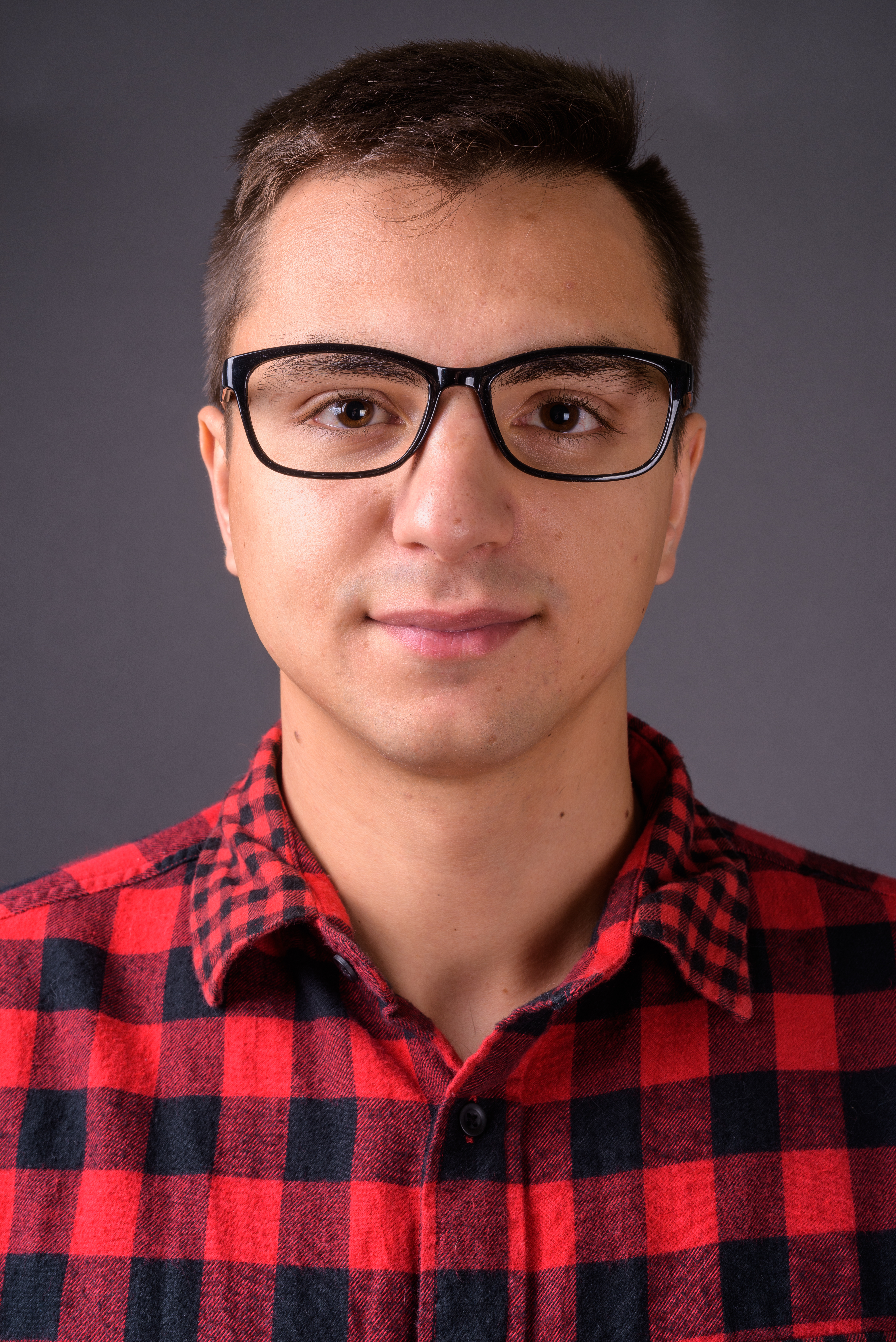 Studio shot of young handsome man against gray background